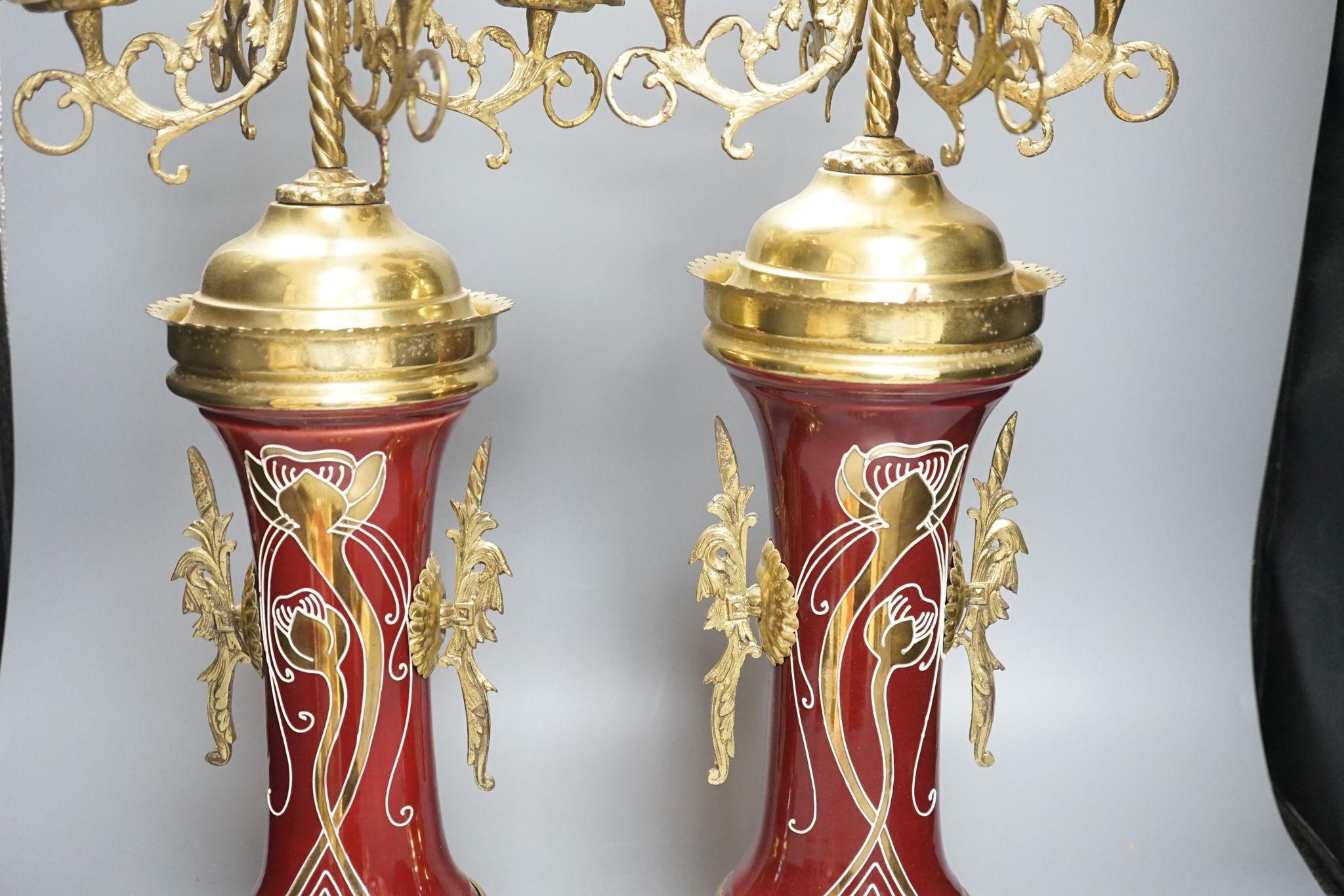 A pair of large brass and ceramic mounted candelabra, 64.5 cms high.